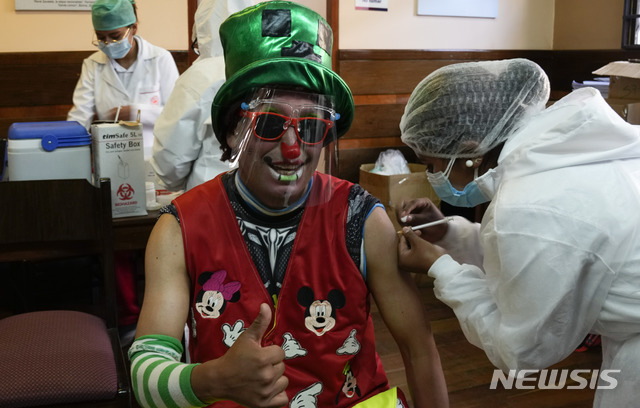 [라파스=AP/뉴시스]볼리비아 정부가 18~30세 사이의 사람들을 대상으로 백신 접종 캠페인을 시행해 5일(현지시간) 라 파스의 산 안드레스 국립대학에 마련된 접종소에서 광대 차림의 한 남성이 시노팜 백신을 접종하고 있다. 2021.07.06.