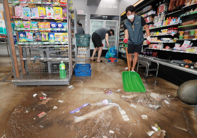 [익산=뉴시스]김얼 기자 = 전북지역에 많은 양의 비가 내린 6일 전북 익산시 창인동의 한 편의점에서 직원들이 물을 빼내고 있다. 2021.07.06. pmkeul@newsis.com 