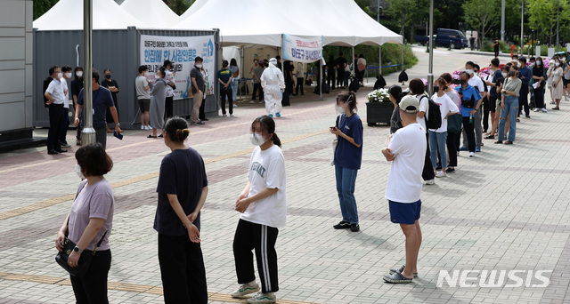 [서울=뉴시스] 이영환 기자 = 코로나19 신규 확진자가 1212명 발생한 7일 오전 서울 마포구 서강대역 광장에 마련된 임시선별검사소에서 시민들이 검사를 받기 위해 줄지어 서 있다. 2021.07.07. 20hwan@newsis.com