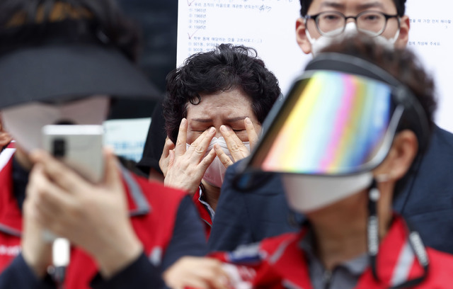 [서울=뉴시스] 홍효식 기자 = 7일 오후 서울 관악구 서울대학교 행정관 앞에서 민주노총 조합원들이 서울대학교 청소 노동자 李모 조합원 사망 관련 서울대 오세정 총장 규탄 기자회견을 하고 있는 가운데 청소 노동자가 눈물을 훔치고 있다. 2021.07.08. yesphoto@newsis.com