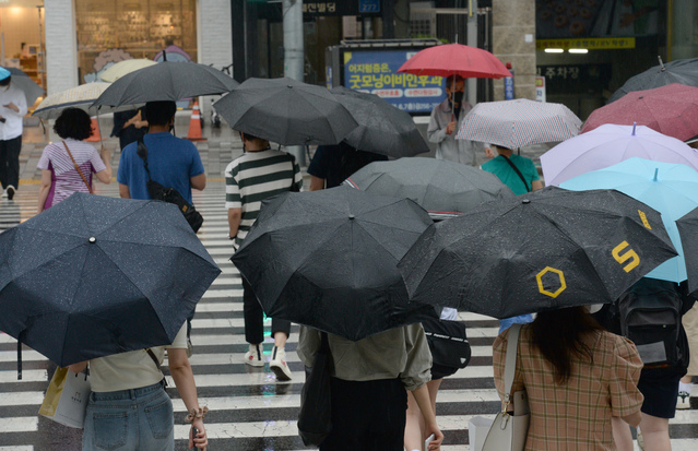 [울산=뉴시스] 배병수 기자 = 울산전역에 호우특보가 내려진 지난 7일 오후 울산 남구 롯데호텔 맞은편 행단보도에 우산을 쓴 시민들이 길을 건너고 있다. 2021.07.07. bbs@newsis.com