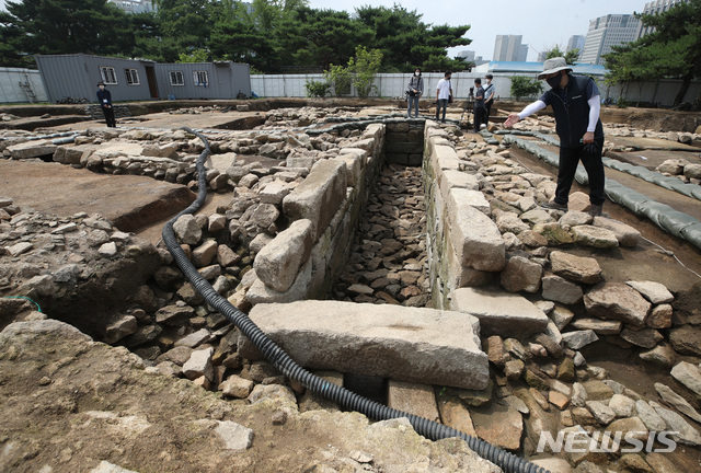 [서울=뉴시스]조수정 기자 = 문화재청 관계자가 8일 오전 서울 종로구 경복궁 동궁 권역에서 발굴된 150년 전(추정) 선진 정화시설을 갖춘 공중화장실 유구(遺構) 현장에 대해 설명하고 있다. 가운데 직사각형 석조 공간이 화장실 유구, 왼쪽으로 난 두갈래 물길은 출수구, 아래는 입수구다. 2021.07.08. chocrystal@newsis.com