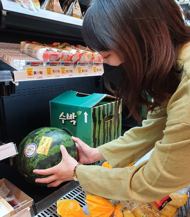 [서울=뉴시스]편의점 이마트24를 찾은 한 고객이 수박 한 통을 집어드는 모습. (사진=이마트24 제공). 2021.07.10. photo@newsis.com *재판매 및 DB 금지
