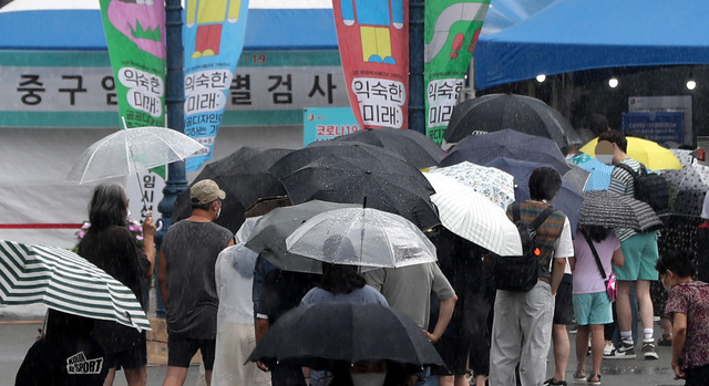 [서울=뉴시스] 추상철 기자 =  지난달 10일 오전 서울 중구 서울역광장에 마련된 중구 임시선별진료소에서 소나기속 검사를 받으려는 시민들이 길게 줄지어 서 있다. 2021.07.10. scchoo@newsis.com