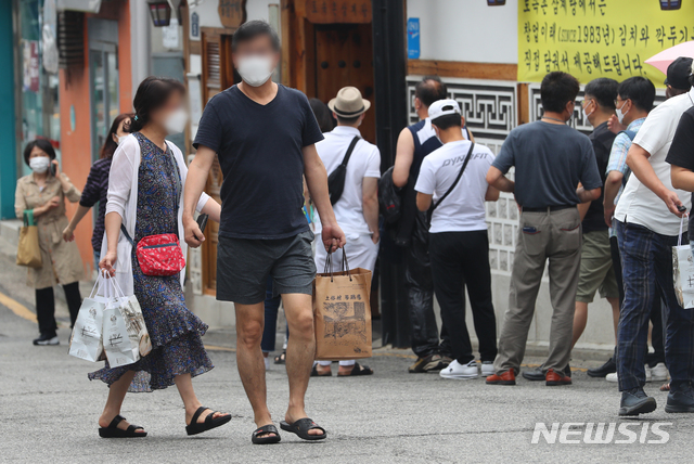 [서울=뉴시스] 배훈식 기자 = 수도권 사회적 거리두기 4단계 격상을 하루 앞둔 11일 오전 서울 종로구의 한 삼계탕 판매점 앞에 초복을 맞은 시민이 포장 주문한 삼계탕을 가져가고 있다. 2021.07.11. dahora83@newsis.com