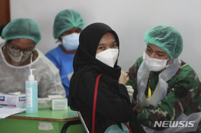 [자카르타=AP/뉴시스] 12일(현지시간) 인도네시아 자카르타에서 한 청소년이 코로나19 시노백 백신을 접종하고 있다. 최근 코로나19 델타 변이 등이 폭증하면서 인도네시아 정부가 일반인들로부터 돈을 받고 코로나19 백신 접종하는 것을 허용했다가 반대 여론에 부딪혀 이를 잠정 연기했다. 2021.07.12.