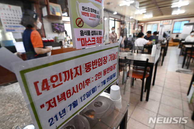 [수원=뉴시스] 김종택기자 = 코로나19 확산으로 사적모임 인원이 2명까지로 제한되는 등의 수도권 사회적 거리두기 4단계 첫날인 12일 오후 경기도 수원시 팔달구 한 식당에 관련 안내문이 붙어있다. 2021.07.12. jtk@newsis.com