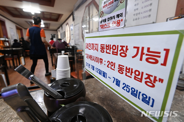 [수원=뉴시스] 김종택기자 = 코로나19 확산으로 사적모임 인원이 2명까지로 제한되는 등의 수도권 사회적 거리두기 4단계 첫날인 12일 오후 경기도 수원시 팔달구 한 식당에 관련 안내문이 붙어있다. 2021.07.12.jtk@newsis.com