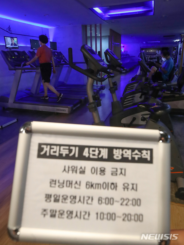 [서울=뉴시스] 조수정 기자 = 사회적 거리두기 4단계 첫날인 12일 서울 은평구 연신내 한 헬스장에서 회원들이 런닝머신 등 기구를 이용하고 있다. 헬스장에서는 샤워실을 이용할 수 없고 런닝머신은 시속 6km이하의 속도를 유지해야 한다. 2021.07.12. chocrystal@newsis.com