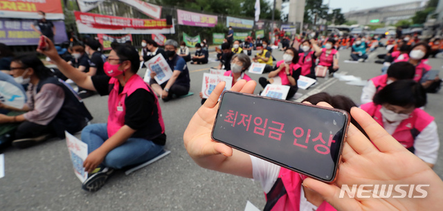 [세종=뉴시스] 강종민 기자 = 전국민주노동조합총연맹 조합원들이 12일 오후 최저임금위원회 전원회의가 열리고 있는 정부세종청사 고용노동부 앞에서 투쟁문화제를 열고 최저임금 인상을 촉구하고 있다. (공동취재사진) 2021.07.12. photo@newsis.com