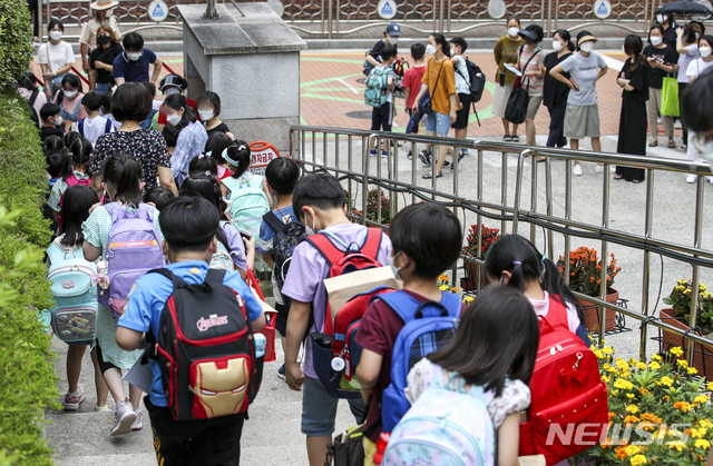 [서울=뉴시스] 정병혁 기자 = 13일 오전 서울시내의 한 초등학교에서 학생들이 하교하고 있다. 코로나19 확산으로 수도권 사회적 거리두기 4단계가 시행되면서 관내 유치원과 초·중·고·특수학교가 원격수업으로 전환한다. 서울의 경우 학사일정 조정, 돌봄 공백을 최소화하기 위한 준비 기간 등을 고려해 14일부터 25일까지 원격수업으로 전환한다. 2021.07.13. jhope@newsis.com