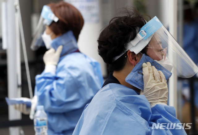 [서울=뉴시스] 홍효식 기자 = 전국 대부분 지역에 폭염 특보가 발효된 13일 서울 동작구청 주차장에 마련된 임시 선별검사소에서 의료진들이 아이스팩으로 더위를 식히고 있다. 2021.07.13. yesphoto@newsis.com