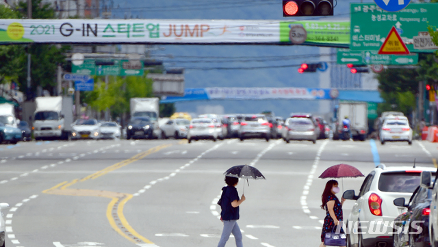 [광주=뉴시스] 류형근 기자 = 폭염 특보가 내려진 지난 13일 오후 광주 서구 쌍촌동에서 시민들이 바쁜 걸음으로 건널목을 건너고 있다. 2021.07.13. hgryu77@newsis.com