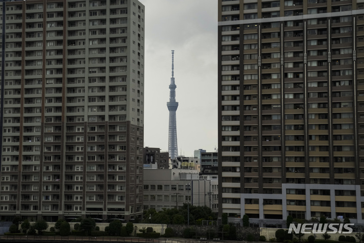 The Tokyo Skytree, the tallest structure in Japan, is seen between two apartment buildings Tuesday, July 13, 2021, in Tokyo. The pandemic-delayed 2020 Summer Olympics are schedule to open on July 23 with spectators banned from most Olympic events due to COVID-19 surge. (AP Photo/Jae C. Hong)