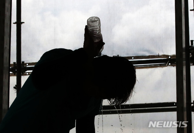 [서울=뉴시스] 김선웅 기자 = 서울의 한 공사현장에서 현장관계자가 생수를 머리에 뿌리며 더위를 식히고 있다. 기사 내용과 관계 없음. 2021.07.14. mangusta@newsis.com