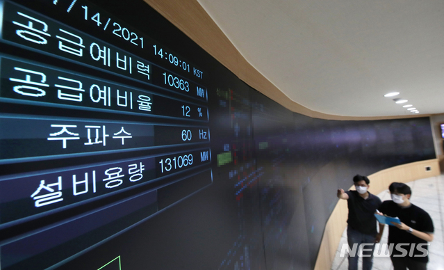 [수원=뉴시스] 김종택기자 = 연일 계속되는 폭염으로 전력수요가 급증하고 있는14일 오후 경기도 수원시 한국전력공사 경기지역본부 전력관리처 계통운영센터에서 관계자들이 전력수급 현황을 살펴보고 있다. 2021.07.14. jtk@newsis.com