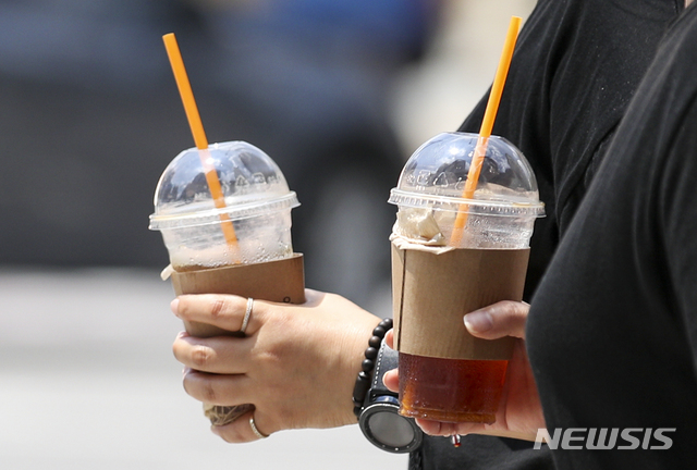 [서울=뉴시스] 정병혁 기자 = 폭염이 이어지고 있는 15일 오후 서울 중구 명동 인근에서 음료를 든 시민들이 이동하고 있다. 2021.07.15. jhope@newsis.com