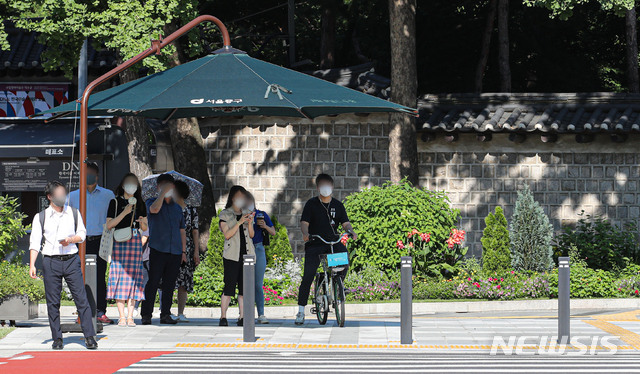 [서울=뉴시스] 권창회 기자 =폭염이 이어지고 있는 16일 오전 서울 중구 시청역 인근에서 시민들이 그늘막 아래서 더위를 피해 신호를 기다리고 있다. 2021.07.16. kch0523@newsis.com