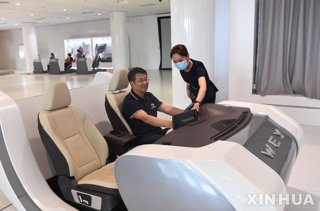 [바오딩=신화/뉴시스] 지난 15일 중국 허베이성 바오딩에 있는 창청자동차 기술센터를 찾은 고객이 신에너지차 모형을 조작하고 있다. 올해 상반기 중국에서 신에너지차는 110만대 이상 신규 등록할 정도로 인기를 끌고 있다. 2021.07.18