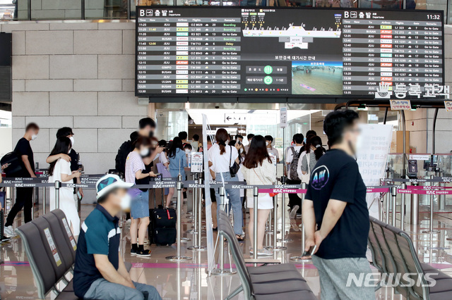 [서울=뉴시스] 김병문 기자 = 수도권 코로나19 사회적 거리두기 4단계 시행 후 첫 주말인 18일 오전 서울 강서구 김포공항 국내선에서 시민들이 탑승 수속을 밟고 있다. 2021.07.18. dadazon@newsis.com