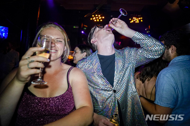 [런던=AP/뉴시스] 19일(현지시간) 영국 런던 파링던의 피아노 웍스가 재개장한 후 젊은이들이 무도장에 올라 춤을 추며 술을 마시고 있다. 이날 0시를 기해 코로나19 방역 규제가 완전히 해제되면서 수천 명의 젊은이는 '자유의 날' 파티를 열어 춤을 추며 밤을 보내는 것으로 알려졌다. 영국 정부는 최근 델타 변이로 코로나19 일일 확진자가 5만 명을 넘어서는 와중에도 규제를 완전 해제했다. 2021.07.19.