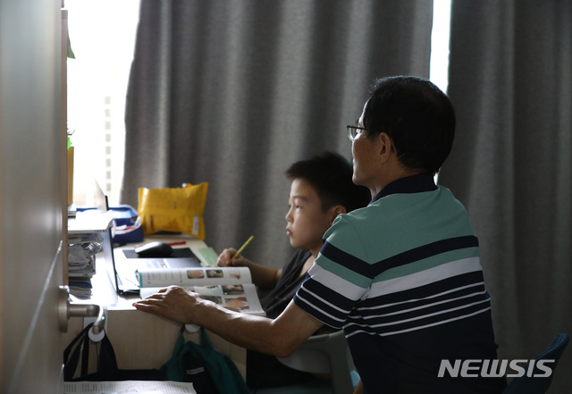 [서울=뉴시스] 조수정 기자 = 19일 오전 서울시내 한 가정에서 코로나19로 등교가 중단되며 온라인 수업을 듣는 초등학교 4, 2학년 두 손자의 외할아버지가 맞벌이를 하는 딸과 사위를 대신해 육아하고 있다. 2021.07.19. chocrystal@newsis.com