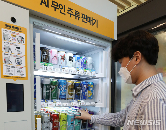 [서울=뉴시스] 백동현 기자 = 19일 오후 서울 성동구 이마트24 본점에서 한 시민이 AI 무인 주류 판매기를 이용하고 있다. 2021.07.19 livertrent@newsis.com
