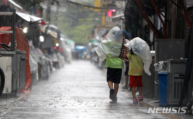 [서울=뉴시스] 추상철 기자 = 소나기가 내린 지난 19일 오후 서울 중구 황학동 주방거리 인근에서 어린이들이 비닐봉지를 머리에 쓰고 발걸음을 재촉하고 있다. 2021.07.19. scchoo@newsis.com