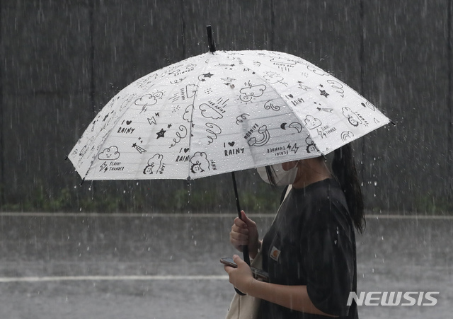 [서울=뉴시스] 고승민 기자 = 오후 들어 서울지역에 폭우가 내린 지난달 7월19일 서울 중구의 한 대형 빌딩 앞에서 우산을 쓴 시민이 발걸음을 재촉하고 있다. 2021.07.19. kkssmm99@newsis.com