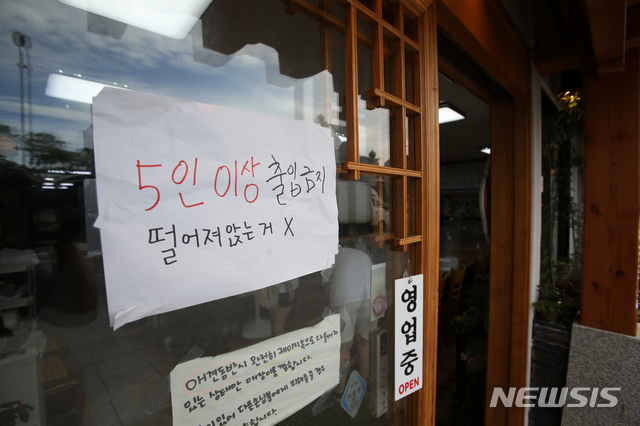 [강릉=뉴시스] 김경목 기자 = 사회적 거리두기 4단계가 시행된 첫날인 19일 오후 강원도 강릉시 경포해수욕장의 인근 식당에서 5인 이상 출입이 안 된다는 홍보를 하고 있다. 2021.07.19. photo31@newsis.com