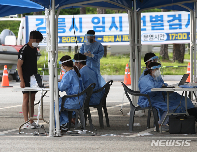 [강릉=뉴시스] 김경목 기자 = 사회적 거리두기 4단계가 시행된 첫날인 19일 오후 한 시민이 강원도 강릉시 유천택지 임시선별진료소를 찾아 코로나19 진단검사를 받기 위한 절차를 밟고 있다. 2021.07.19. photo31@newsis.com