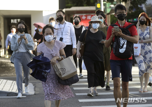 [타이베이=AP/뉴시스] 지난 5월 중순 이래 코로나19 환자가 급증한 대만 수도 타이베이 중심가에서 19일 예방을 위해 마스크를 착용한 시민들이 횡단보도를 바빠 건너고 있다. 2021.07.22  