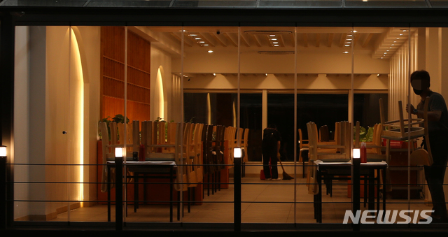 [강릉=뉴시스] 김경목 기자 = 사회적 거리두기 4단계가 시행된 첫날인 19일 오후 강원도 강릉시 경포해수욕장의 한 음식점이 오후 8시가 되자 영업을 끝내고 있다. 4단계에서는 오후 6시부터 8시까지 2인까지만 실내에서 식사를 할 수 있고 오후 8시부터 10시까지 포장만 가능하다. 2021.07.19. photo31@newsis.com