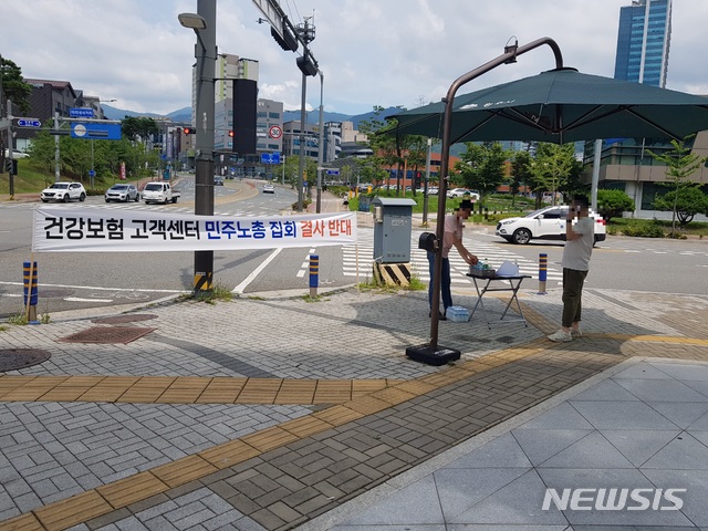 [서울=뉴시스] 강원도 원주 건강보험공단 인근에서 배호석 원주혁신도시상인회 회장이 지역주민들을 대상으로 반대 서명을 받고 있다. 