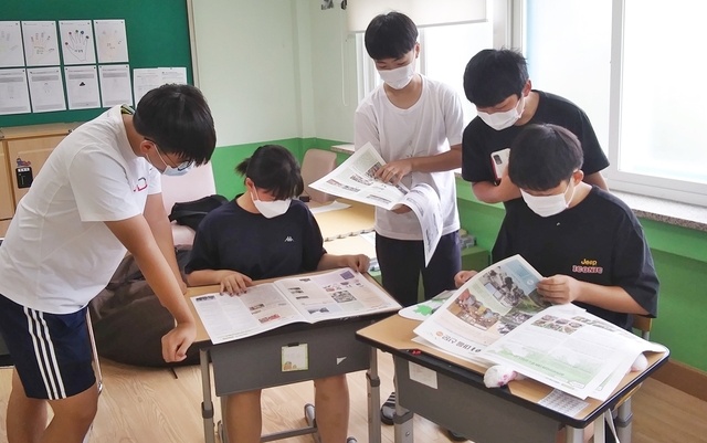 [괴산=뉴시스]강신욱 기자 = 충북 괴산군 청천면 송면중학교 학생들이 '솔맹이 마을 신문' 창간호를 살펴보고 있다. (사진=송면중 제공) 2021.07.20. photo@newsis.com  *재판매 및 DB 금지