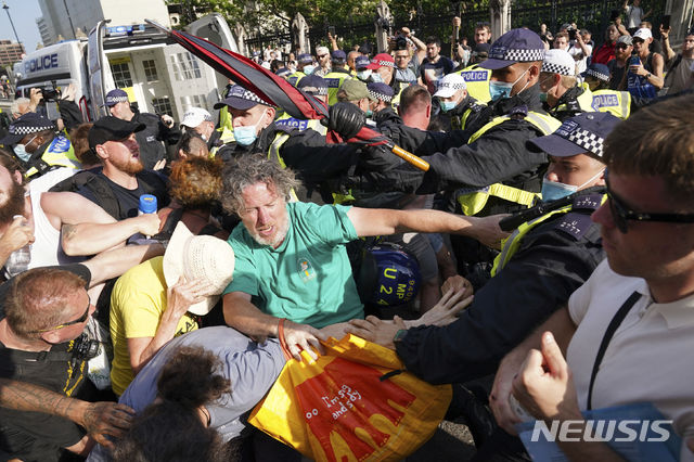 [런던=AP/뉴시스] 영국에서 코로나19 규제가 완전히 해제된 19일(현지시간) 런던 의회 광장에 모인 백신 반대 시위대가 경찰과 충돌하고 있다. 영국 잉글랜드 지역은 이날부터 사회적 거리 두기, 실내 마스크 착용, 모임 인원 통제 등 코로나19 제한 조치를 종료해 '자유의 날'을 선포했으며 보리스 존슨 총리는 '개인의 판단과 책임'을 강조했다. 2021.07.20.