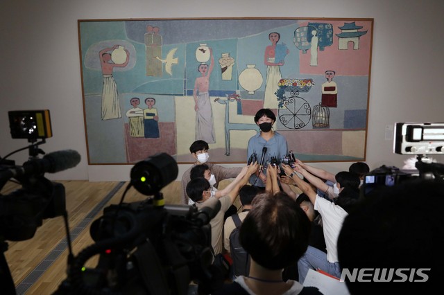 [서울=뉴시스] 박진희 기자 = 국립현대미술관 박미화 학예연구관이 20일 서울 종로구 서울관에서 진행된 'MMCA 이건희컬렉션 특별전: 한국미술명작' 언론공개 행사에서 작품 설명을 하고 있다. 배경 그림은 김환기의 '여인들과 항아리'. 전시는 내일부터 2022년 3월 13일까지. 2021.07.20. pak7130@newsis.com