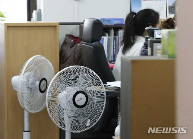 [서울=뉴시스] 김명원 기자 = 20일 서울 종로구 정부서울청사 한 부처에서 공무원들이 창문을 열고, 선풍기를 켜고 근무를 하고 있다. 2021.07.20. kmx1105@newsis.com