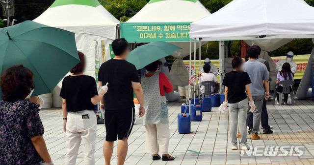 [부산=뉴시스] 하경민 기자 = 부산지역 코로나19 확진자가 급증세인 21일 오전 연제구 부산시청 등대광장 임시선별검사소를 찾은 시민들이 진단검사를 받기 위해 줄을 선채 차례를 기다리고 있다. 2021.07.21. yulnetphoto@newsis.com