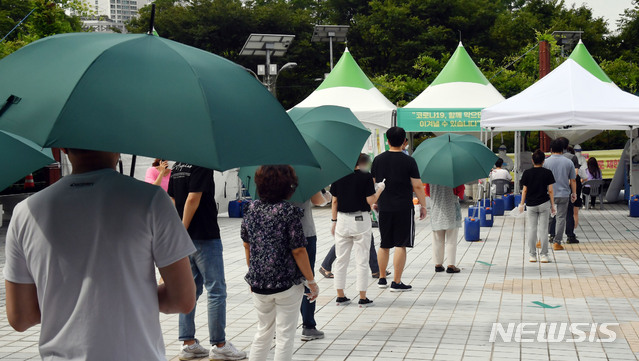 [부산=뉴시스] 하경민 기자 = 부산지역 코로나19 확진자가 급증세인 21일 오전 연제구 부산시청 등대광장 임시선별검사소를 찾은 시민들이 진단검사를 받기 위해 줄을 선채 차례를 기다리고 있다. 2021.07.21. yulnetphoto@newsis.com