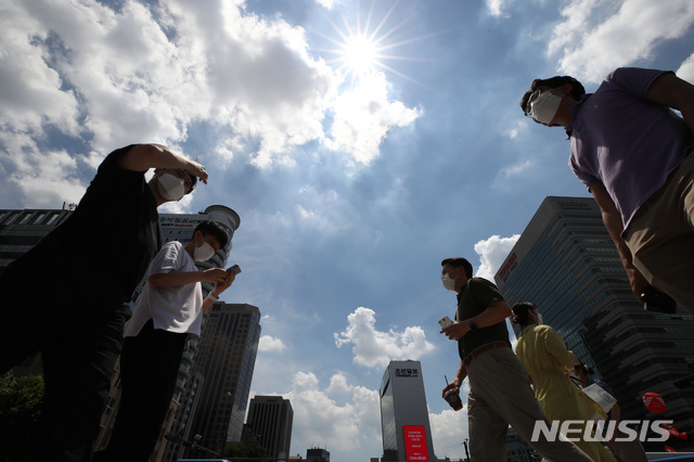 [서울=뉴시스] 조수정 기자 = 중복인 지난 21일 오후 서울 종로구 세종로 네거리에서 시민들이 뜨거운 햇살 아래 발걸음을 재촉하고 있다. 2021.07.21. chocrystal@newsis.com