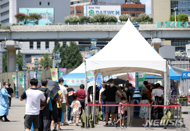 [서울=뉴시스] 김선웅 기자 = 지난 21일 오후 서울역광장 선별검사소에서 시민들이 검사를 받기 위해 우산을 쓰거나 천막 아래서 기다리고 있다  2021.07.21. mangusta@newsis.com