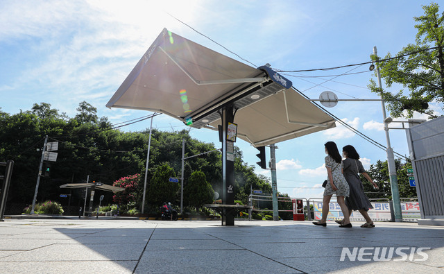 [서울=뉴시스] 권창회 기자 = 연일 폭염이 이어지고 있는 지난 21일 오후 서울 용산구 녹사평역 인근 교차로에 '스마트 그늘막'이 펼쳐져 있다. '스마트 그늘막'은 온도·바람 등 기상변화에 따라 자동으로 개폐된다. 2021.07.21. kch0523@newsis.com