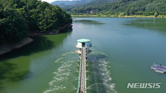 [수원=뉴시스] 김종택기자 = 연일 계속되는 폭염으로 전국 대부분의 저수지에 녹조현상이 발생한 22일 오후 경기도 수원시 장안구 광교저수지에 녹조방지 살수장치가 가동되고 있다. 2021.07.22. jtk@newsis.com