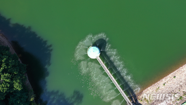[수원=뉴시스] 김종택기자 = 연일 계속되는 폭염으로 전국 대부분의 저수지에 녹조현상이 발생한 22일 오후 경기도 수원시 장안구 광교저수지에 녹조방지 살수장치가 가동되고 있다. 2021.07.22. jtk@newsis.com