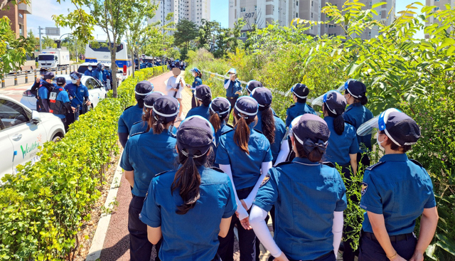 [원주=뉴시스] 김경목 기자 = 23일 오후 경찰이 강원도 원주시 국민건강보험공단 사옥 인근 인도에서 한 여성을 둘러싼 가운데 검문을 하고 있다. (사진=독자 제공) 2021.07.23. photo@newsis.com *재판매 및 DB 금지