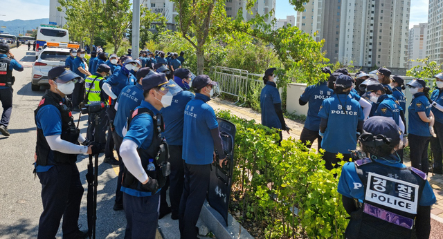 [원주=뉴시스] 김경목 기자 = 23일 오후 경찰이 강원도 원주시 국민건강보험공단 사옥 인근 인도에서 언덕을 넘어 집결하는 민주노총 노조원들의 진입을 차단하기 위해 경계근무를 서고 있다. (사진=독자 제공) 2021.07.23. photo@newsis.com 