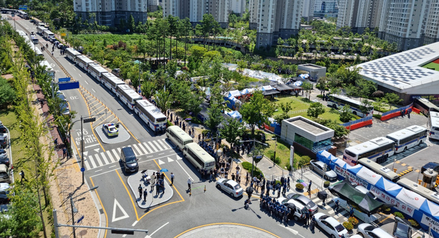 [원주=뉴시스] 김경목 기자 = 23일 오후 경찰이 강원도 원주시 국민건강보험공단 사옥 인근 도로에 차벽을 세우고 있고 국민건강보험공단 고객센터노조는 집회를 진행하고 있다. (사진=독자 제공) 2021.07.23. photo@newsis.com 