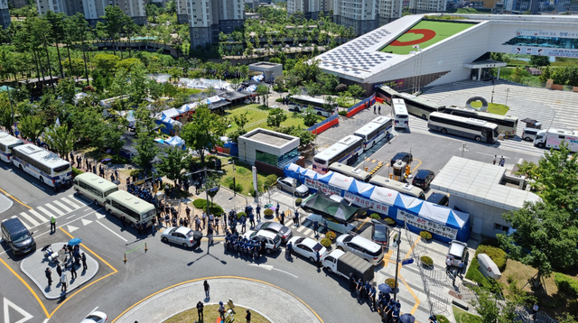 [원주=뉴시스] 김경목 기자 = 23일 오후 경찰이 강원도 원주시 국민건강보험공단 사옥 인근 도로에 차벽을 세우고 있고 국민건강보험공단 고객센터노조는 집회를 진행하고 있다. (사진=독자 제공) 2021.07.23. photo@newsis.com *재판매 및 DB 금지