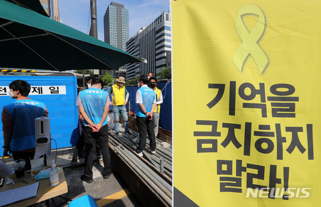 [서울=뉴시스] 배훈식 기자 = 세월호 유족, 시민단체 활동가들과 물품 수거를 위해 배치된 서울시 공무원들이 지난 7월24일 오후 서울 종로구 광화문광장 세월호 참사 기억공간 앞에서 대치하고 있다. 2021.07.24. dahora83@newsis.com